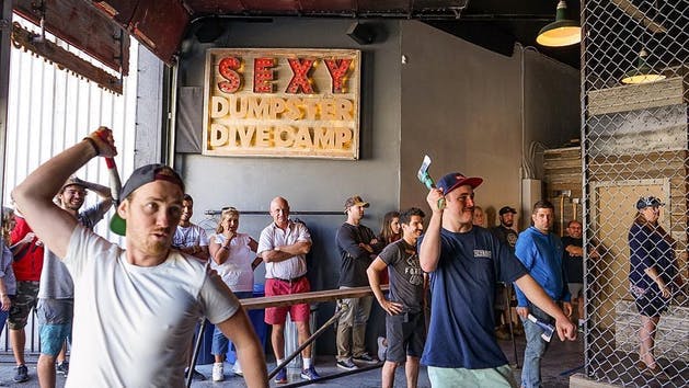 A group of men throw axes at forged