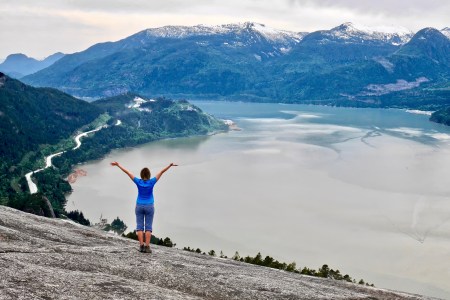 Hiking near Vancouver. Young woman on cliff over the ocean. Stawamus Chief Peak. Squamish. Whistler. British Columbia. Canada.