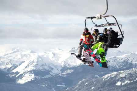 A few friends sit on a chair lift in Whistler