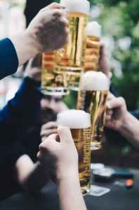 Focus on people holding pints of beer in cheers
