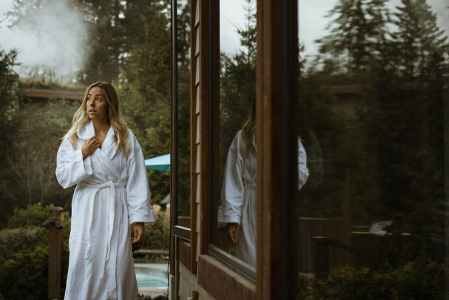 Woman outside a sauna in a bath robe in Whistler