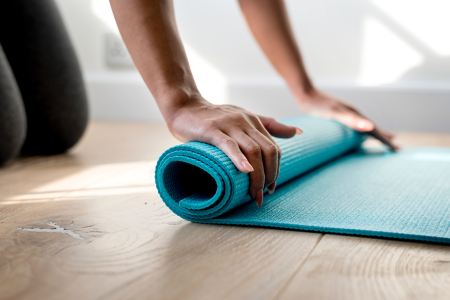 woman rolling up the yoga mat