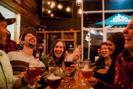 Coast Mountain Brewery shared table with people laughing.