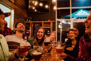 Coast Mountain Brewery shared table with people laughing.