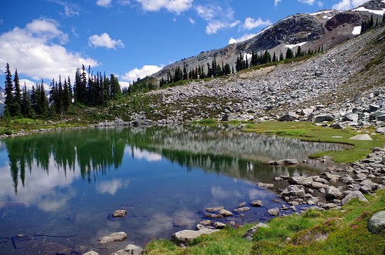 a close up of a hillside next to a body of water, Harmony Lake in Whistler