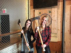 Two women in plaid hold axes at Forged Axe Throwing in Whistler
