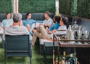 a group of men on an outdoor patio, champagne and beer glasses.