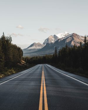 an empty road with a mountain in the background