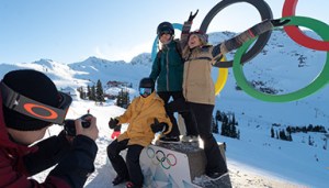 a group of friends poses in front of the whistler olympic park rings