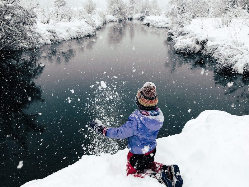 a man riding a snowboard down a snow covered slope