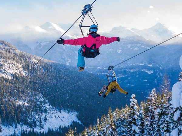 sf-51_600x600_RGB a man flying through the air while riding skis with Whistler Blackcomb in the background